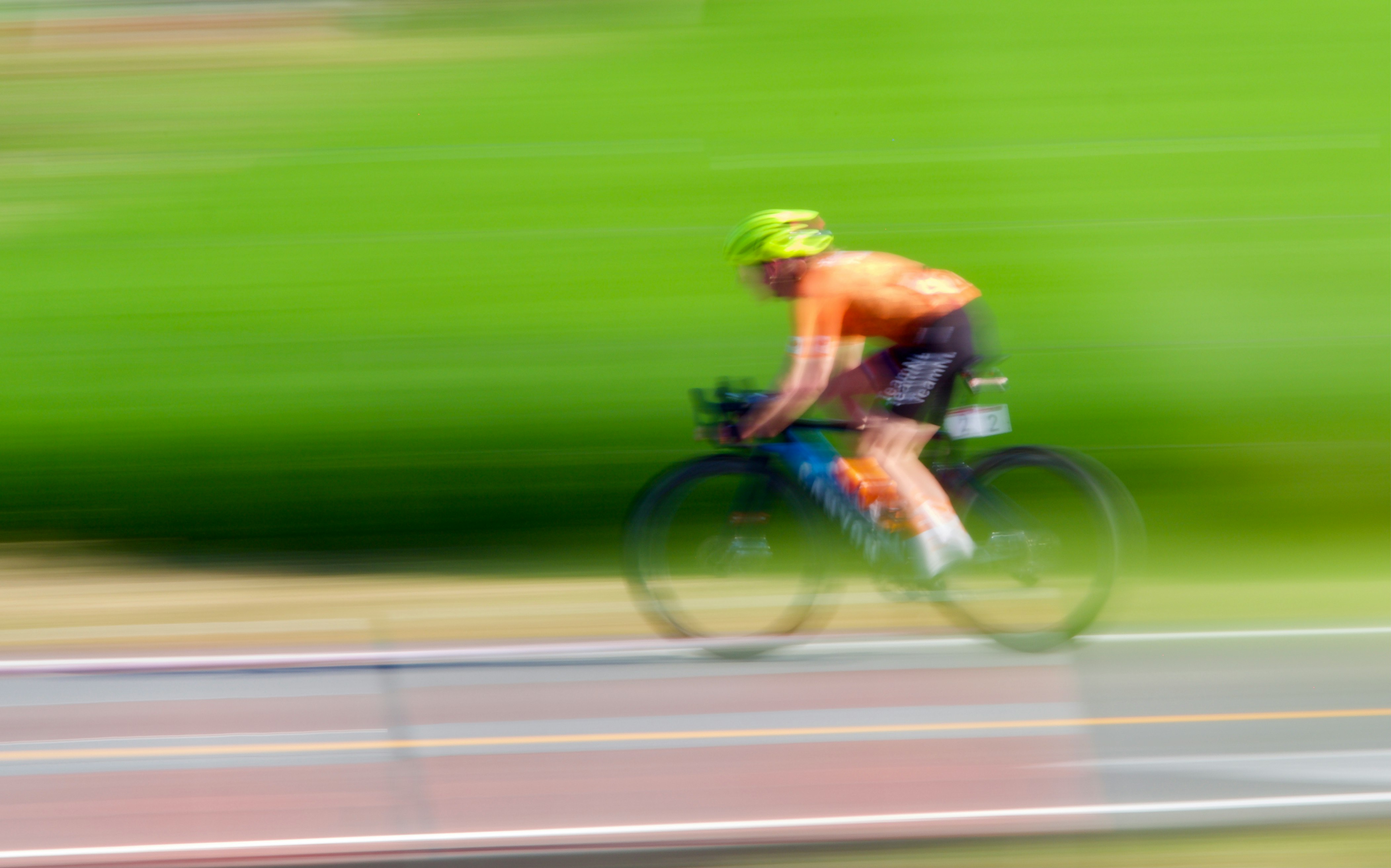 man in green shorts riding on bicycle on road during daytime